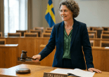Person in courtroom blazer holding gavel above sounding block labeled Ordförande
